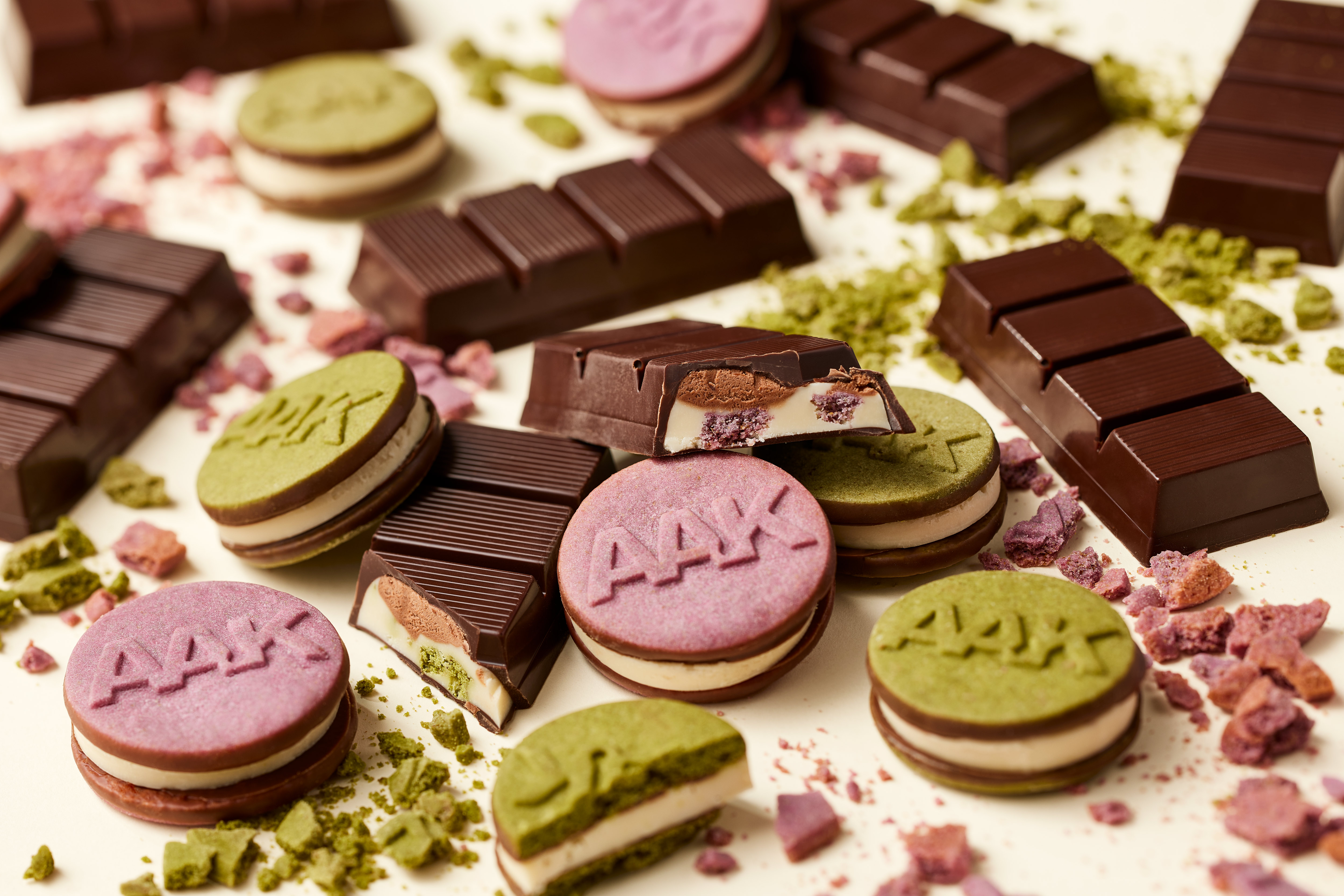 Chocolate bars and cookies with green and pink AAK-stamped tops.