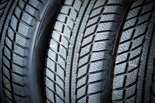 Close-up on three black car tires in a row.